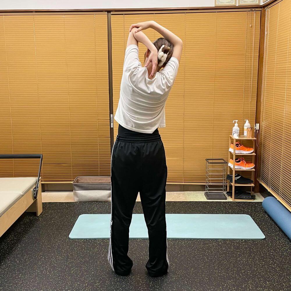 ピラティスエクササイズで腕を抱えて体側を伸ばすストレッチ姿勢2